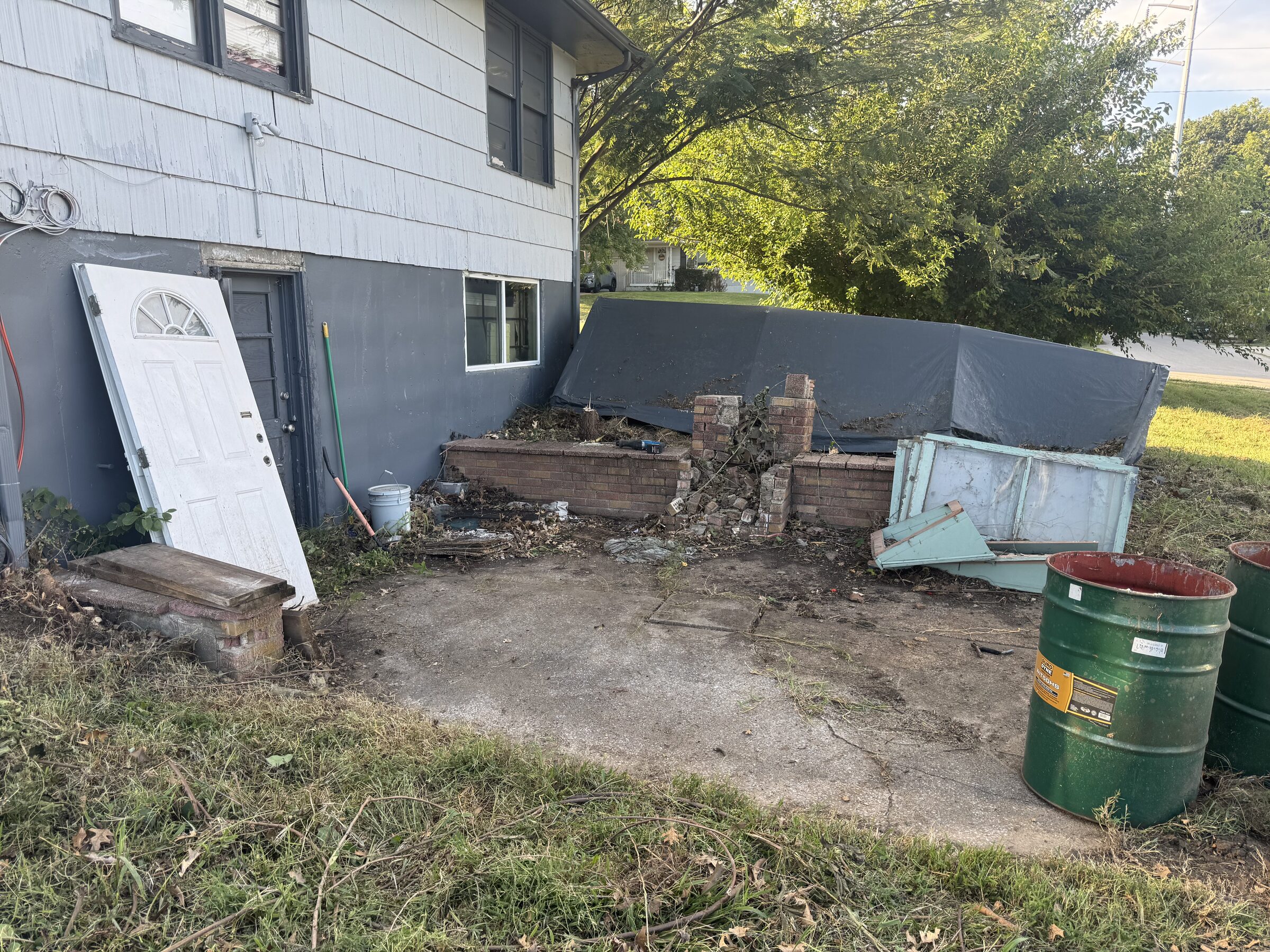 Yard debris and old materials beside a house, ready for cleanup and haul-away